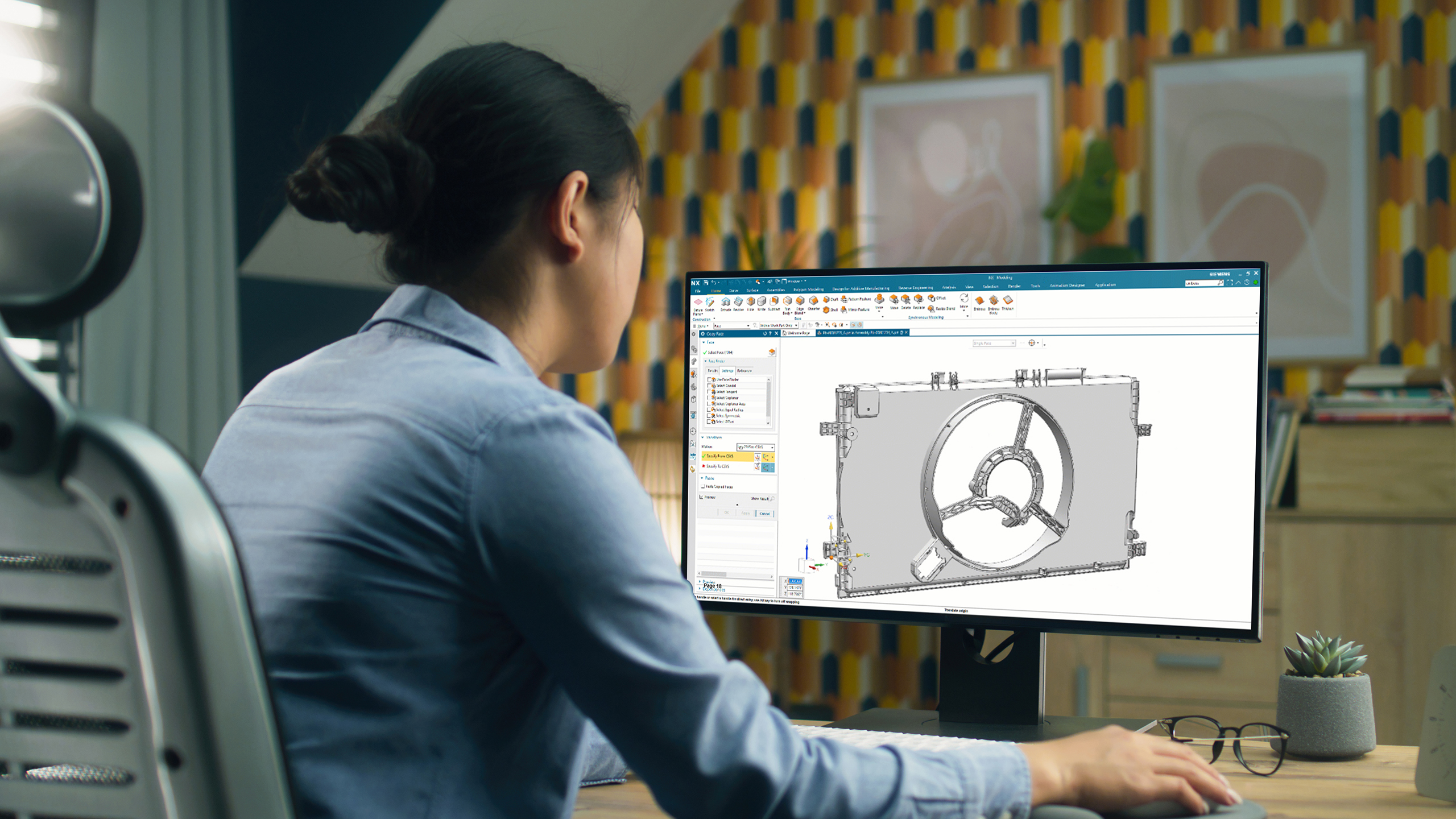 一位设计师看着电脑屏幕上显示的 NX for CAD。